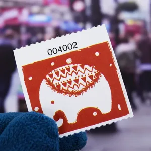 A 2x2 roll ticket displaying a white elephant figure on a red background
